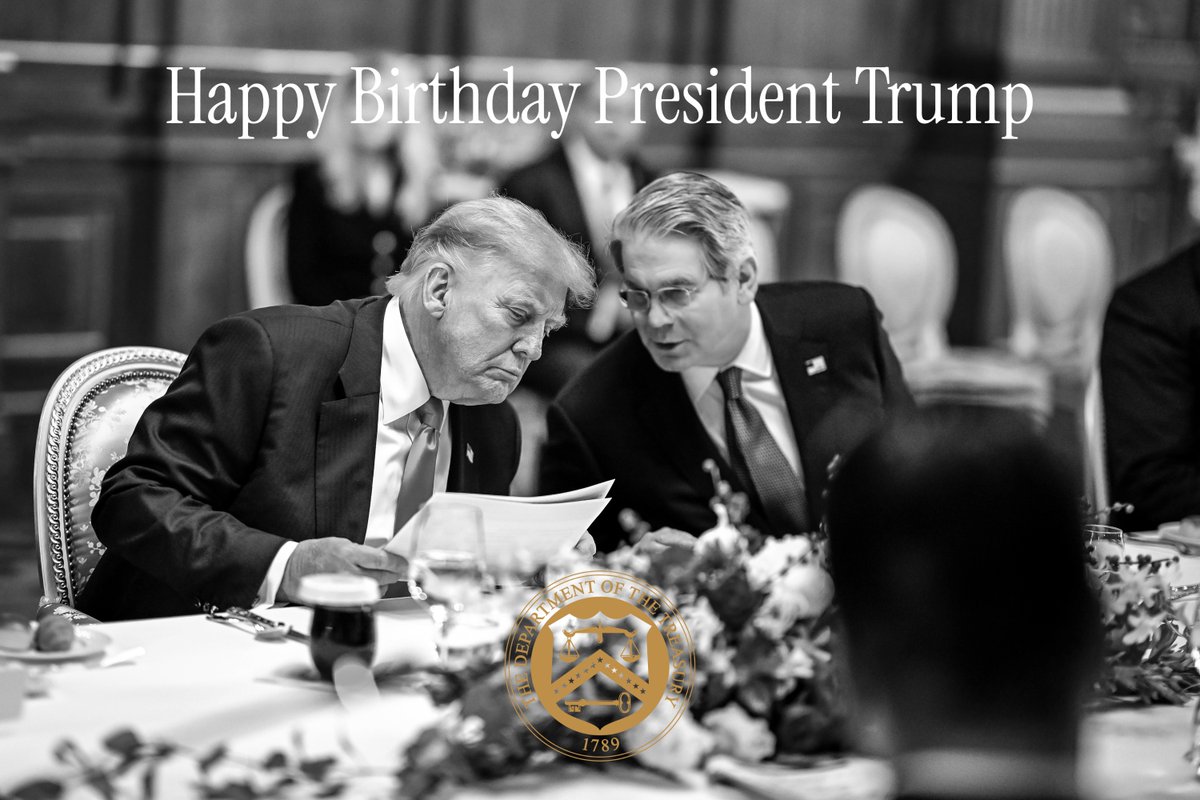 Black and white photo of President Trump and Secretary Bessent seated at a formal dinner table. Overlay text reads "Happy Birthday President Trump". U.S. Department of the Treasury seal is visible.