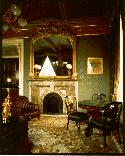 Photograph of the Salmon Chase Suite. Sitting table and stone fireplace.